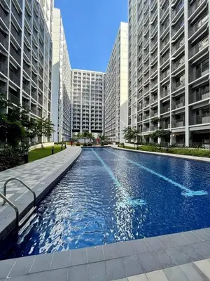 a large swimming pool in a city with tall buildings at Tower 3 Shore 2 High Floor 1BR Good 4PAX in Manila