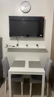a white table with chairs and a clock on a wall at Tower 3 Shore 2 High Floor 1BR Good 4PAX in Manila