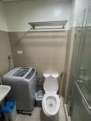 a small bathroom with a toilet and a shower at Tower 3 Shore 2 High Floor 1BR Good 4PAX in Manila