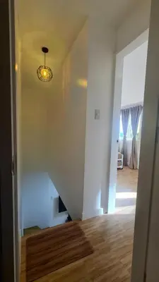 a hallway with a stairway leading to a living room at Tahanan - Victoria de Makati in Manila