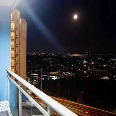 a view of a city at night from a building at Gabila Staycation at Azure in Manila