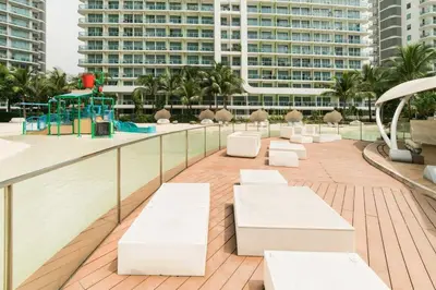a deck with white benches and a playground on a building at Gabila Staycation at Azure in Manila