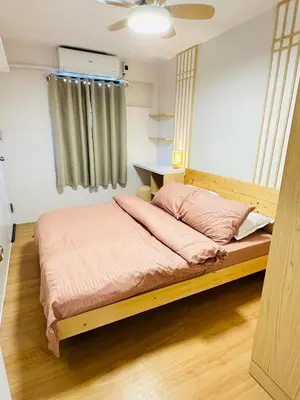 a bed with a wooden frame in a room at Tiffany's Place in Imus