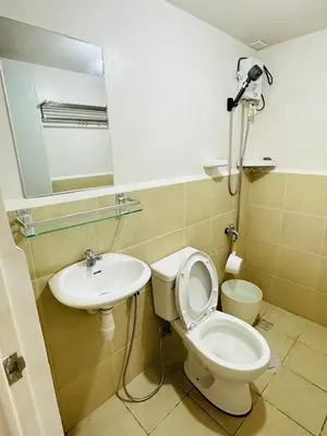 a bathroom with a toilet and a sink and a mirror at Tiffany's Place in Imus