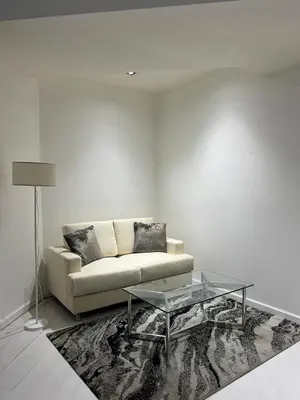 a living room with a couch and a glass table at Affordable Staycation with Balcony at The Gramercy Makati in Manila