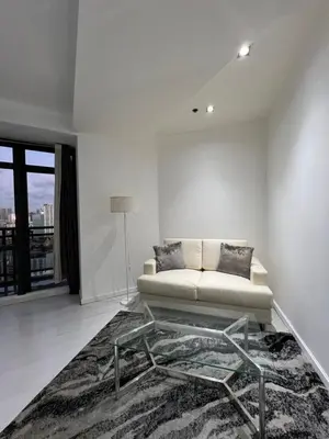 a white living room with a couch and a rug at Affordable Staycation with Balcony at The Gramercy Makati in Manila