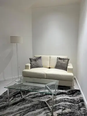 a living room with a couch and a glass coffee table at Affordable Staycation with Balcony at The Gramercy Makati in Manila