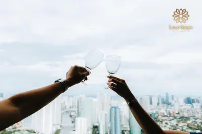 two people holding up wine glasses in front of a city at Affordable Staycation with Balcony at The Gramercy Makati in Manila