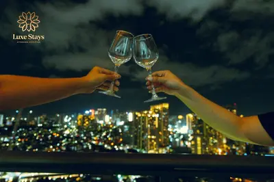 two people holding wine glasses over a city skyline at Affordable Staycation with Balcony at The Gramercy Makati in Manila