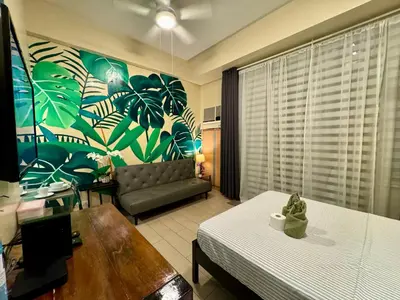 a living room with a bed and a couch at Beautiful Studio Near Resorts World NAIA T3 in Manila