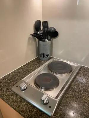 a stove top with some utensils on a counter at Beautiful Studio Near Resorts World NAIA T3 in Manila