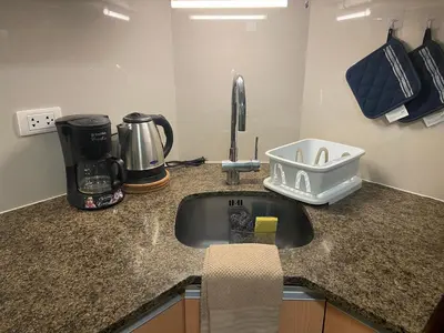 a kitchen counter with a sink and a coffee maker at Beautiful Studio Near Resorts World NAIA T3 in Manila