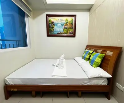 a bed in a room with a picture on the wall at P3K Jazz Staycation in Manila