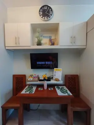 a table with two chairs and a clock on a wall at P3K Jazz Staycation in Manila