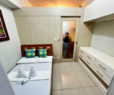 two beds in a small room with a kitchen at P3K Jazz Staycation in Manila