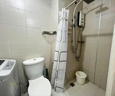 a small bathroom with a toilet and a shower at P3K Jazz Staycation in Manila