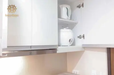 a kitchen with white cabinets and a toaster at Affordable 1BR Staycation at One Uptown BGC in Manila