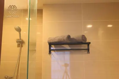a bathroom with a shower with a towel on a shelf at Affordable 1BR Staycation at One Uptown BGC in Manila