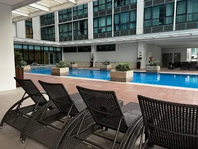 a group of chairs sitting in front of a swimming pool at Affordable 1BR Staycation at One Uptown BGC in Manila