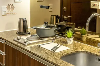 a kitchen counter with a sink with pots and pans at Luxurious 1BR Staycation at One Uptown BGC in Manila