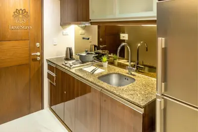 a small kitchen with a sink and a refrigerator at Luxurious 1BR Staycation at One Uptown BGC in Manila