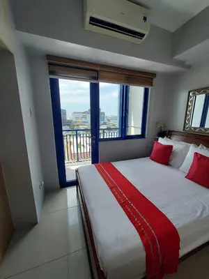 a bedroom with a large bed with a large window at Great Stay in Manila in Manila