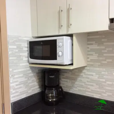 a microwave on a shelf in a kitchen at Great Stay in Manila in Manila