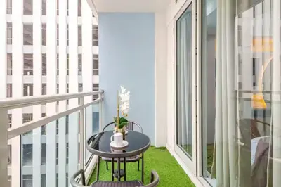 a small table on a balcony with a window at Dsa'sCrib 1BR Azure Near Airport in Manila