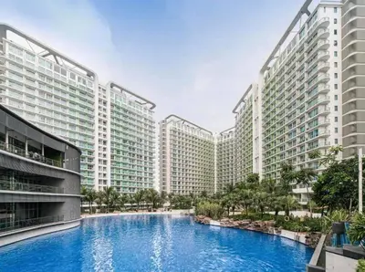 a large swimming pool in front of two tall buildings at Dsa'sCrib 1BR Azure Near Airport in Manila
