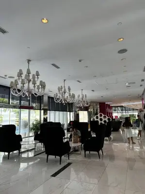 a lobby with black chairs and a table and chandeliers at Dsa'sCrib 1BR Azure Near Airport in Manila