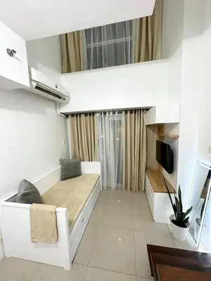 a small room with a bed and a tv at 1bedroom LOFT with Garden Terrace pool access in Manila