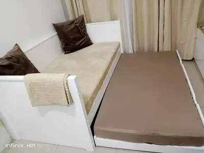 a bed and a chair in a room at 1bedroom LOFT with Garden Terrace pool access in Manila
