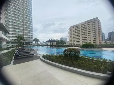a large swimming pool in a city with tall buildings at 1bedroom LOFT with Garden Terrace pool access in Manila