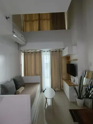 a living room with a couch and a table at 1bedroom LOFT with Garden Terrace pool access in Manila