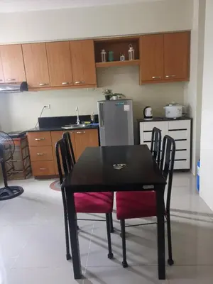 a kitchen with a black table with chairs and a refrigerator at Emjay's staycation in Manila