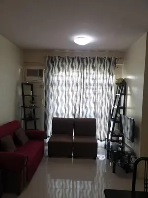 a living room with a couch and a window at Emjay's staycation in Manila