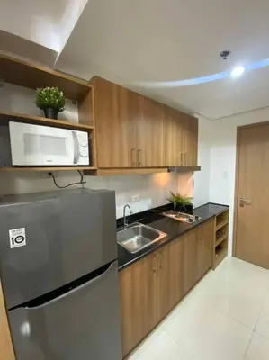 a kitchen with a stainless steel refrigerator and a microwave at Lush Suite Makati in Manila