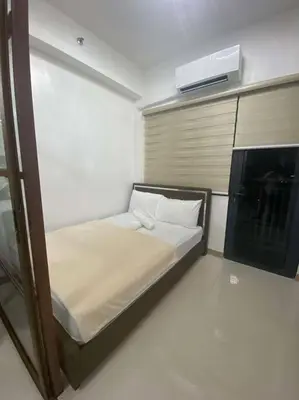 a small bedroom with a bed in a room at Lush Suite Makati in Manila