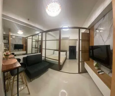 a living room with a couch and a television at Lush Suite Makati in Manila