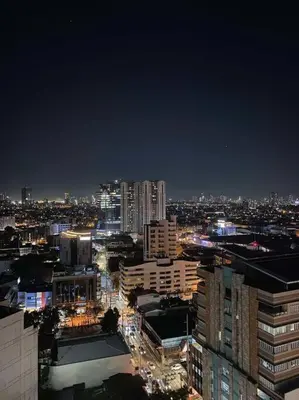 a view of a city at night with buildings at Lush Suite Makati in Manila