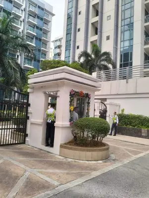 two police officers standing outside of a building at Nadzcondotel - at Two Palm Tree Villas o in Manila
