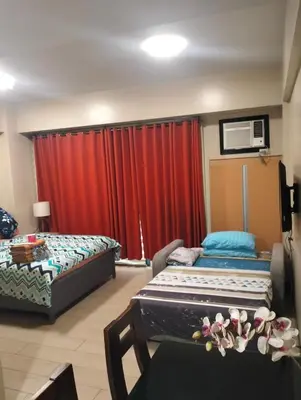 a room with two beds and a red curtain at Nadzcondotel - at Two Palm Tree Villas o in Manila