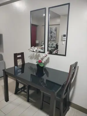 a dining room table with two chairs and a mirror at Nadzcondotel - at Two Palm Tree Villas o in Manila