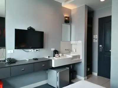 a bathroom with a sink and a tv on the wall at Leez Inn Malate in Manila