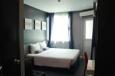 a small bedroom with a bed and a window at Leez Inn Malate in Manila