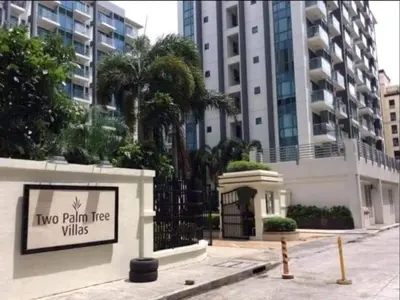 a sign that says two palm trees in front of a building at Infinity Stay in Manila