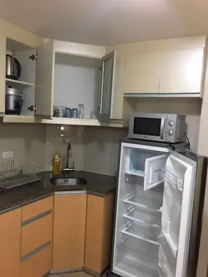 a kitchen with a refrigerator and a microwave at Infinity Stay in Manila