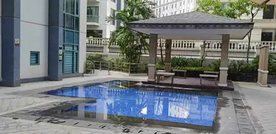 a swimming pool with a gazebo next to a building at Infinity Stay in Manila