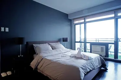a bedroom with a bed with a stuffed animal on it at Spacious and Cozy 2 Br in The Gramercy Poblacion in Manila