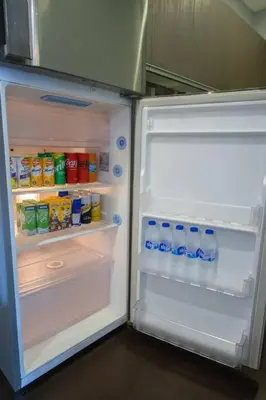 an open refrigerator filled with drinks and milk at Spacious and Cozy 2 Br in The Gramercy Poblacion in Manila